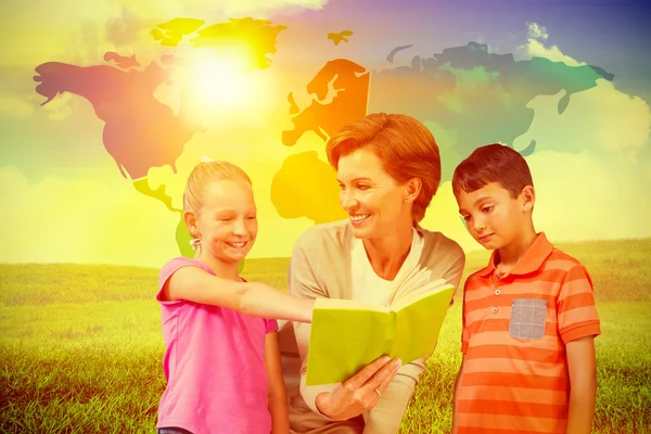 Teacher reading book with pupils at library — Stock Photo, Image