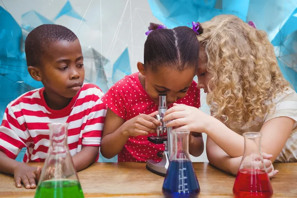 Pupils looking through microscope — Stock Photo, Image