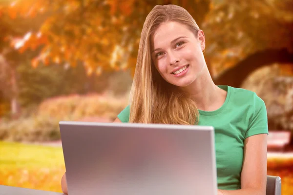 Student op laptop tegen bomen — Stockfoto