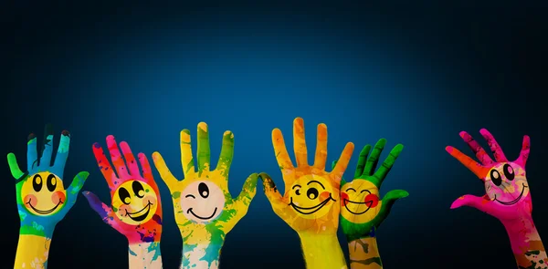 Manos con caras sonrientes coloridas — Foto de Stock