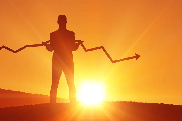 Uomo d'affari con freccia contro un tramonto — Foto Stock