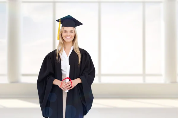 Estudante loira sorridente em roupão de graduação — Fotografia de Stock
