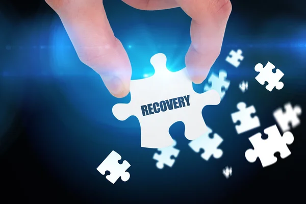 Word recovery and hand holding jigsaw — Stock Photo, Image