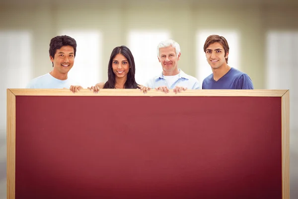 Sammansatta bilden av människor i jeans med en stor skylt — Stockfoto