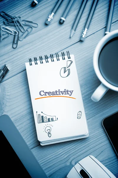 Creativity  against notepad on desk — Stock Photo, Image