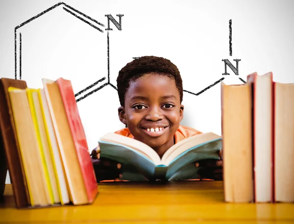 Niño leyendo libro en la biblioteca — Foto de Stock