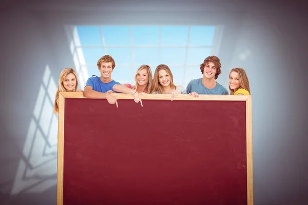 Zusammengesetztes Bild einer lächelnden Gruppe von Menschen mit einer Leerstelle als — Stockfoto