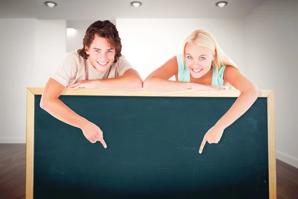 Samengestelde afbeelding van mens en schattig woman wijzend op een whiteboard — Stockfoto