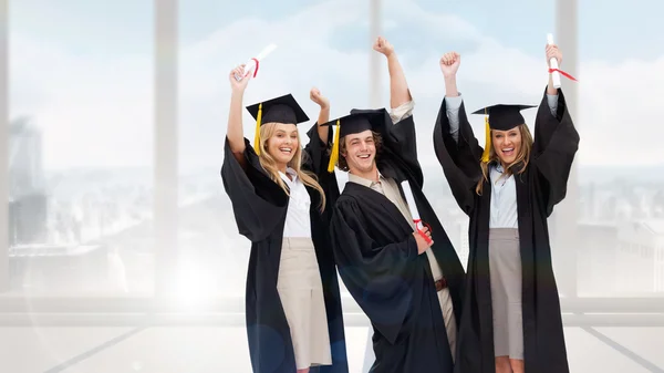 Tre studenter i forskarutbildning mantel — Stockfoto