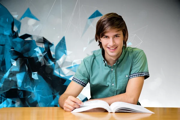 Student sitting in library reading — Stock Photo, Image