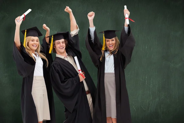 Tres estudiantes en bata de graduado — Foto de Stock