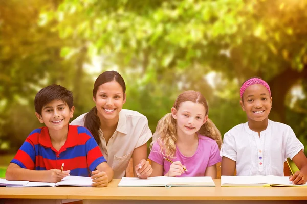 Teacher helping pupils in library — Stock Photo, Image