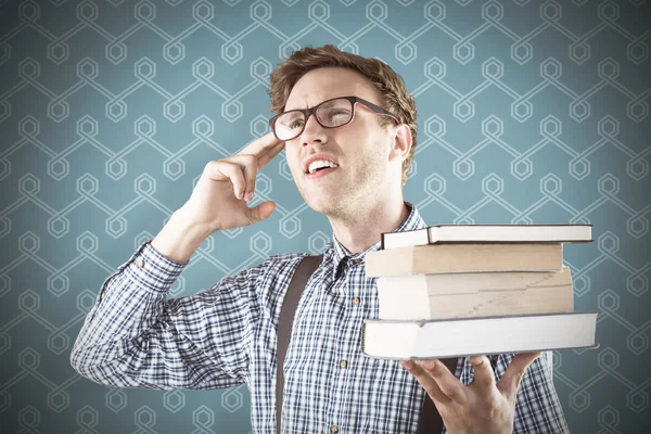 Estudiante geek sosteniendo una pila de libros — Foto de Stock