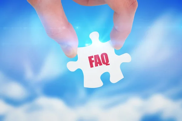 Word faq and hand holding jigsaw — Stock Photo, Image