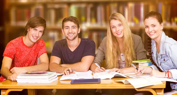 Estudiantes estudiando contra estantería — Foto de Stock