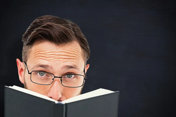 Young geek looking over black book — Stock Photo, Image