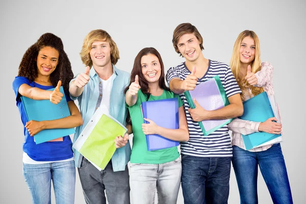 Happy college students gesturing thumbs up Royalty Free Stock Images