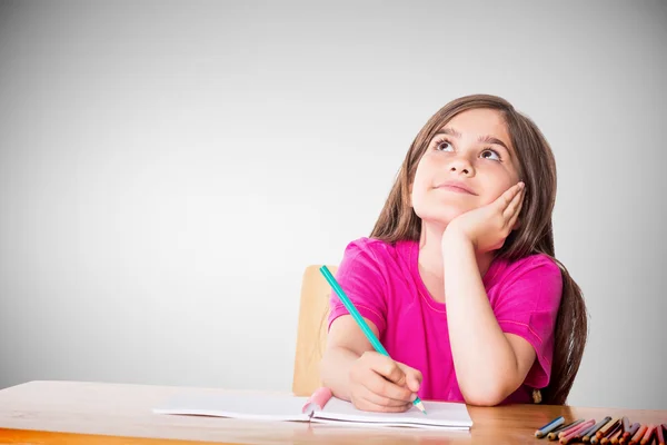 Cute pupil working at her desk Royalty Free Stock Images