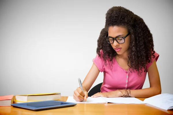 Student sitting in library writing — Stock Photo, Image