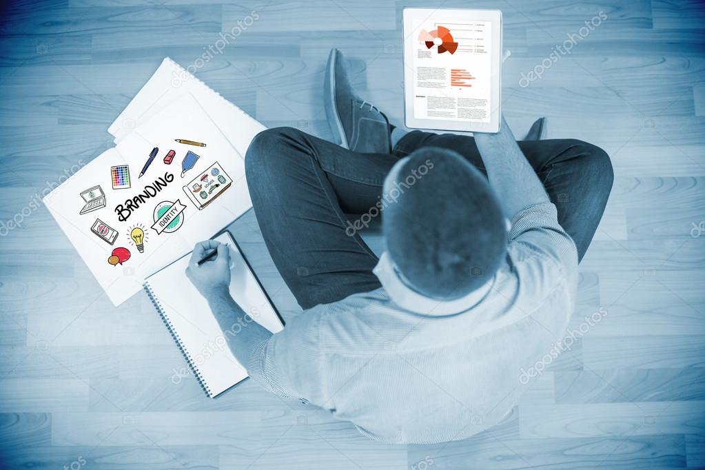 Business graphs against young creative businessman looking at tablet