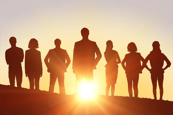 Mensen die zich tegen een zonsondergang — Stockfoto