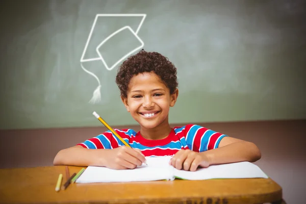 Little boy writing book in classroom — Stock Photo, Image