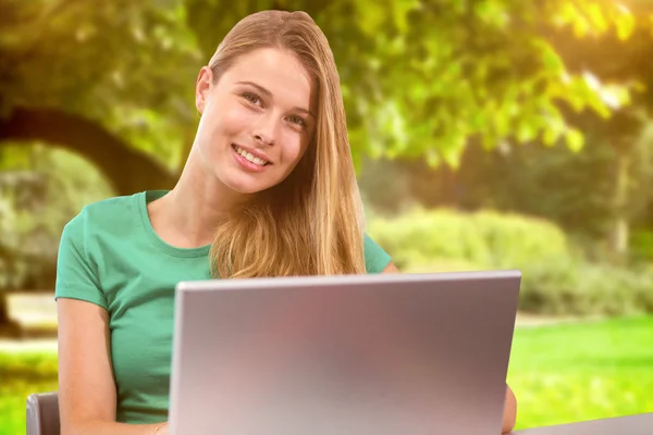 Student på laptop mot träd — Stockfoto