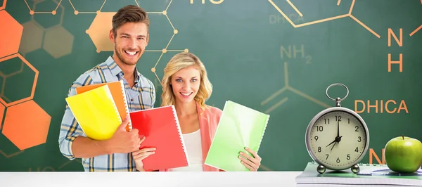 Estudantes sorrindo para a câmera e segurando cadernos — Fotografia de Stock