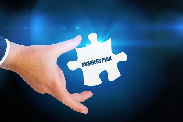 Word business plan and businessman holding jigsaw — Stock Photo, Image