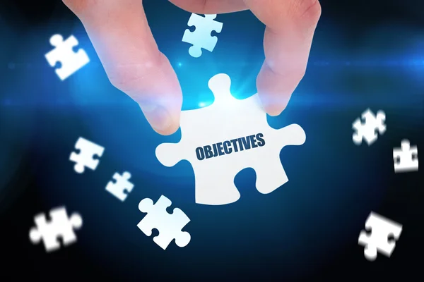 Word objectives  and hand holding jigsaw — Stock Photo, Image