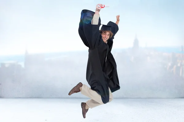 Glückliche männliche Schüler im Abschlussrobe Springen — Stockfoto