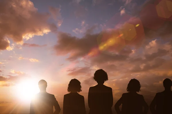 Silhouetten permanent tegen wolken — Stockfoto