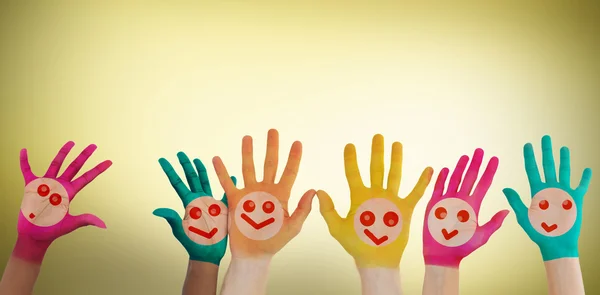 Mãos com caras sorridentes coloridas — Fotografia de Stock