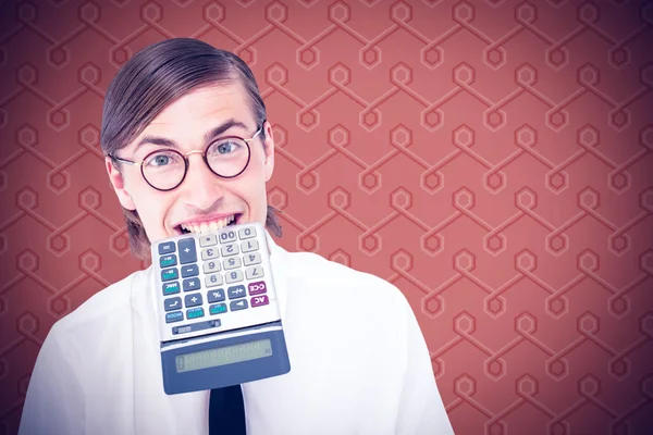 Улыбающийся бизнесмен кусает калькулятор — стоковое фото