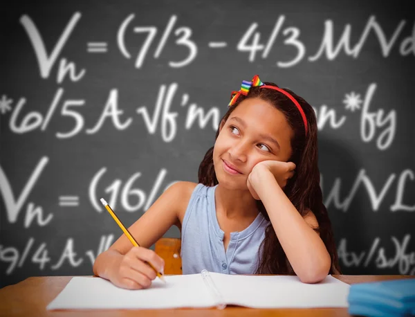 Imagen compuesta de una linda alumna en el escritorio — Foto de Stock