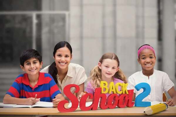 Teacher helping pupils in library — Stock Photo, Image