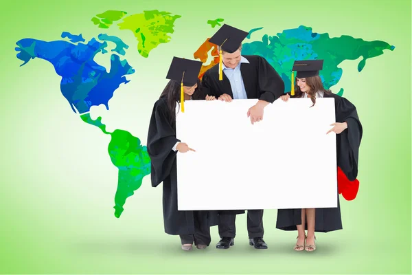 Graduates pointing to the blank sign — Stock Photo, Image