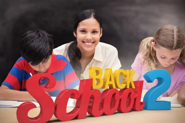 Schöne Lehrerin hilft Schülern in Bibliothek — Stockfoto