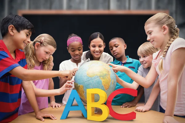 Leerlingen en leraar kijken naar globe — Stockfoto