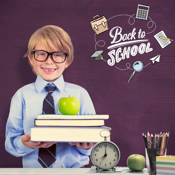 Ученик держит книги и яблоко — стоковое фото