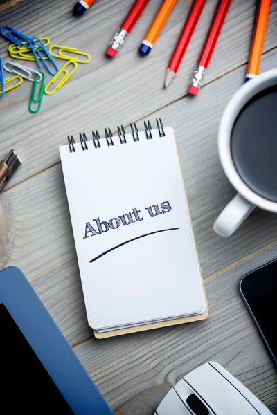 Über uns gegen Notizblock auf dem Schreibtisch — Stockfoto