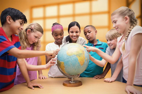 Leerlingen en leraar kijken naar globe — Stockfoto