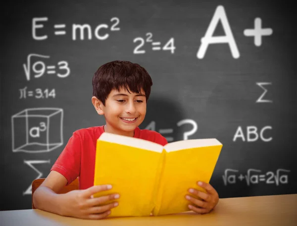 Cute boy reading book in library Stock Image