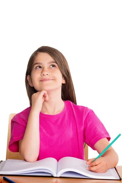 Cute pupil working at her desk Stock Picture