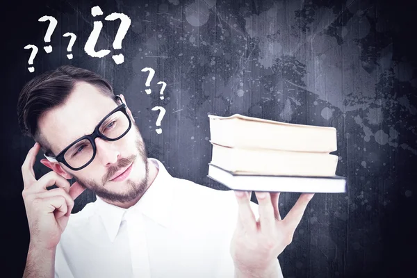 Geeky man looking at pile of books — Stock Photo, Image