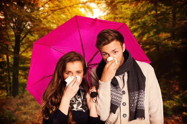 Couple blowing nose while holding umbrella — Stock Photo, Image