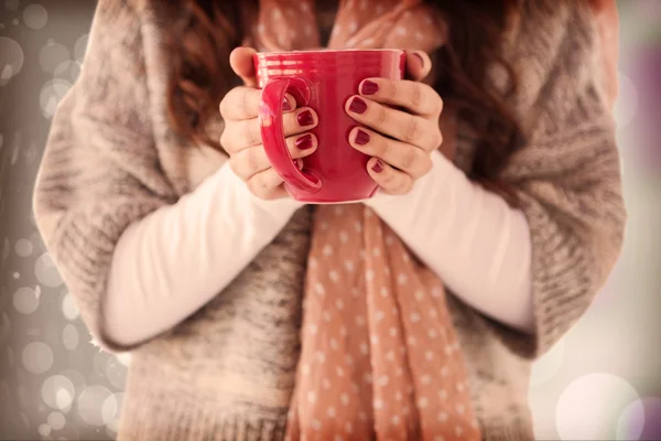 Mujer en ropa de invierno sosteniendo una bebida caliente — Foto de Stock