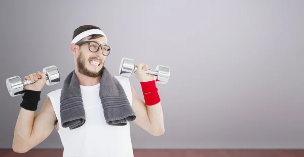 Geeky hipster lifting dumbbells — Stock Photo, Image