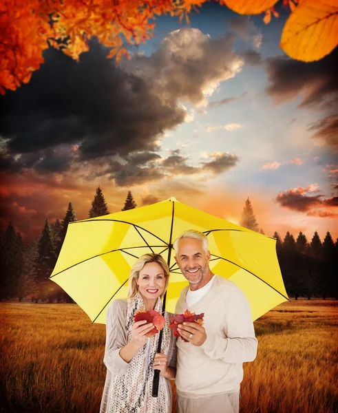 Happy couple under yellow umbrella — Stock Photo, Image