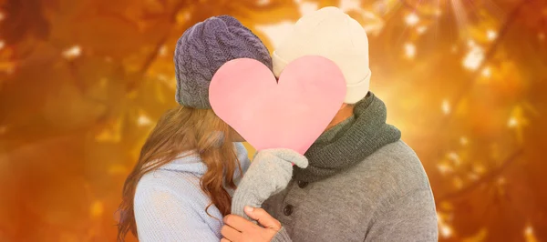 Couple in warm clothing holding heart — Stock Photo, Image